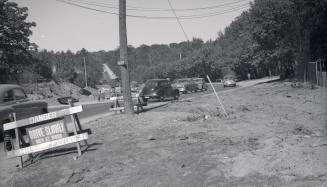 Image shows a street view with some cars on it.