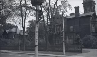 Image shows a traffic light and a house across the street.