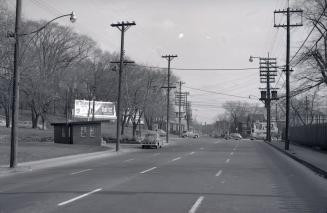 Image shows a street view with trees on both sides.