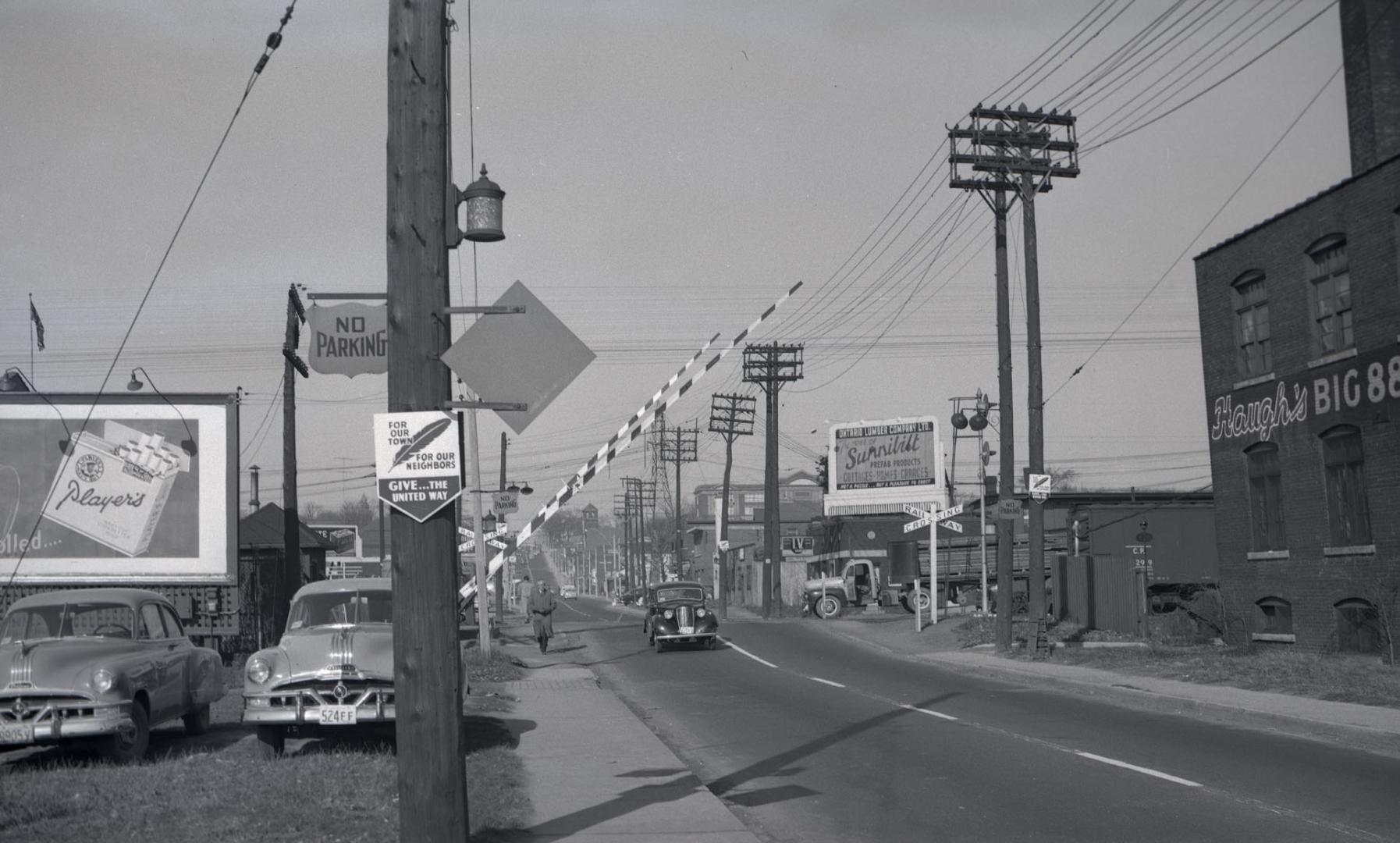 Image shows a street view with a railway crossing.