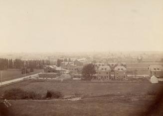 Image shows a view of many houses, the road, and lots of lawn space.