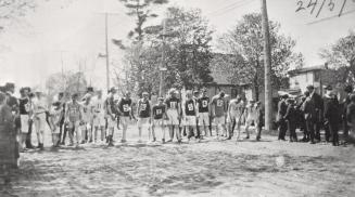 Race, North Toronto. Image shows a group of runners ready to start a race. There are some spect…