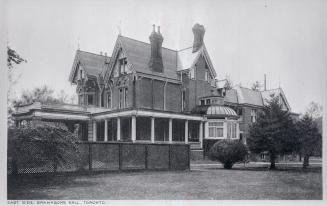 Image shows a three storey house with some trees around it.