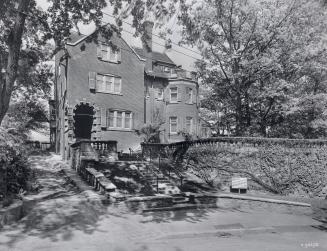 Image shows a three storey house with a staircase in front of it.