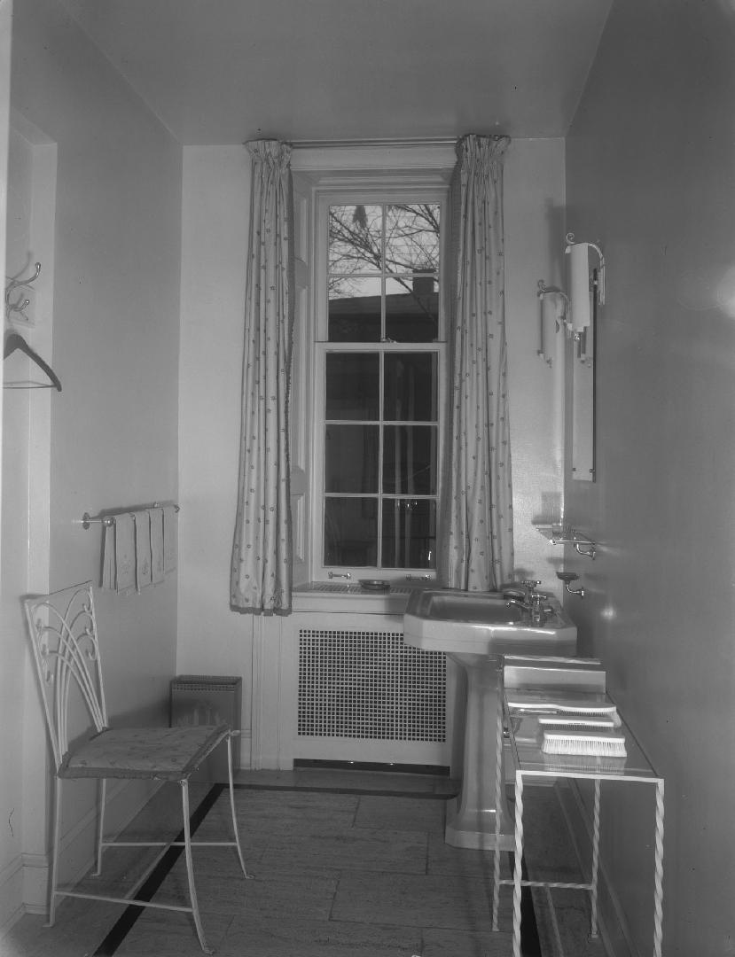 Image shows an interior of the washroom. There is a sink, a chair, a small table against the wa…