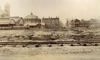 Image shows train tracks and some buildings in the background.