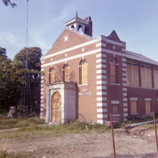 Emery Public School, Toronto, Ontario. Image shows a two storey building that has some wood on …