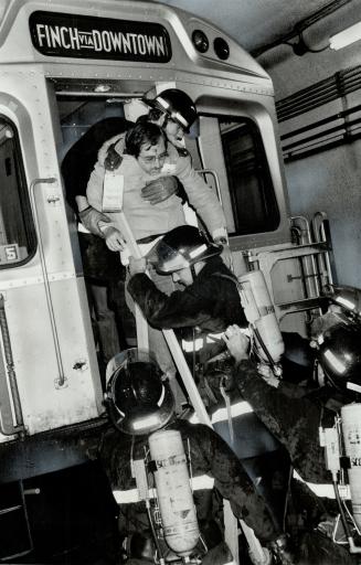 Firemen pulling crash victim from the back of a a Finch and Downtown subway car.