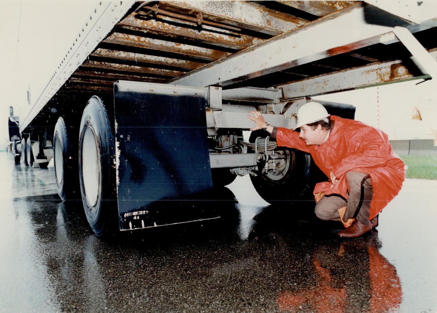 Safety check: Roger Davis of the provincial transport ministry checks truck for safety violations at a roadside weigh station