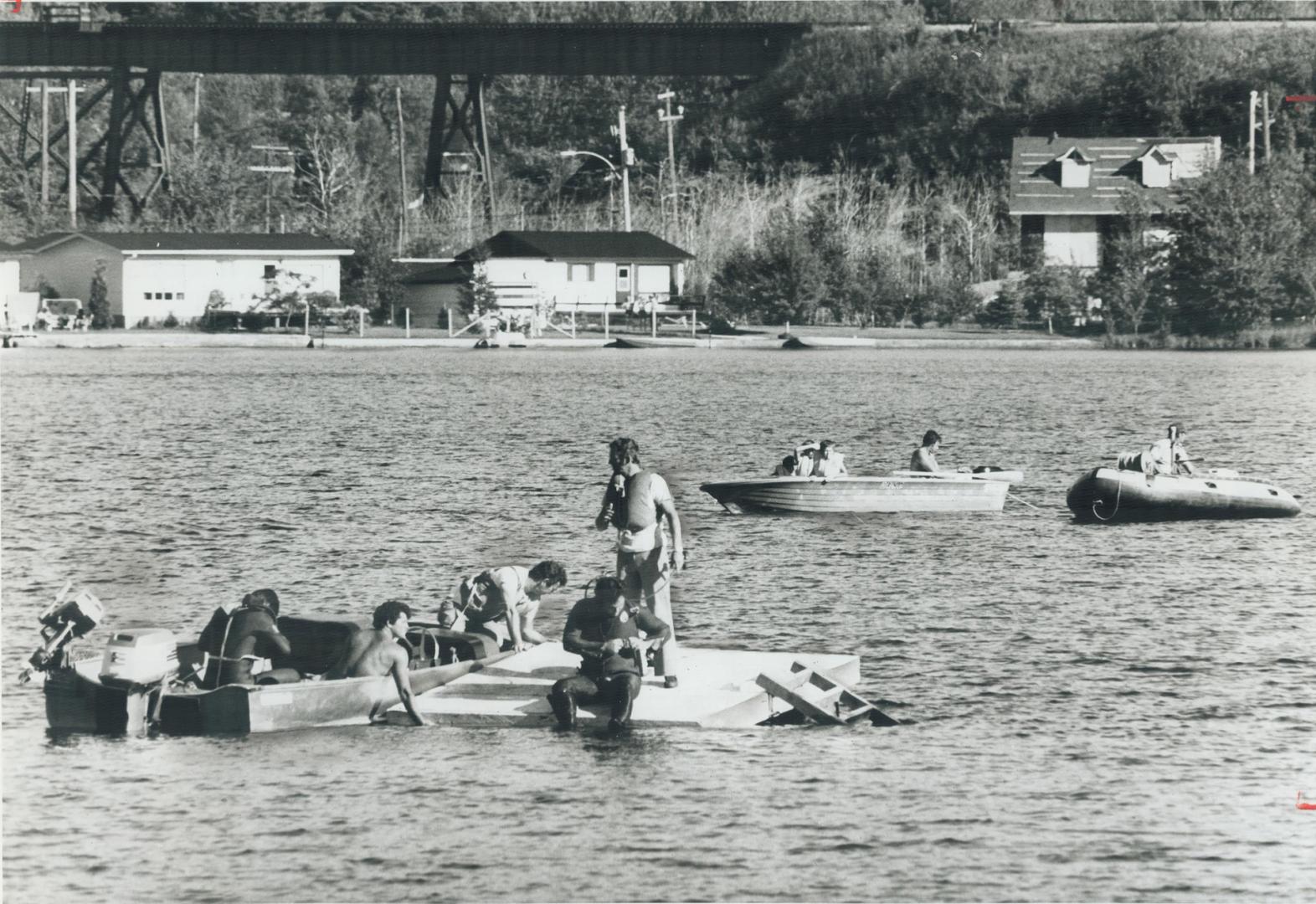 Teams of divers work on an attempt yesterday to raise the bus that sank in Lac d'Argent