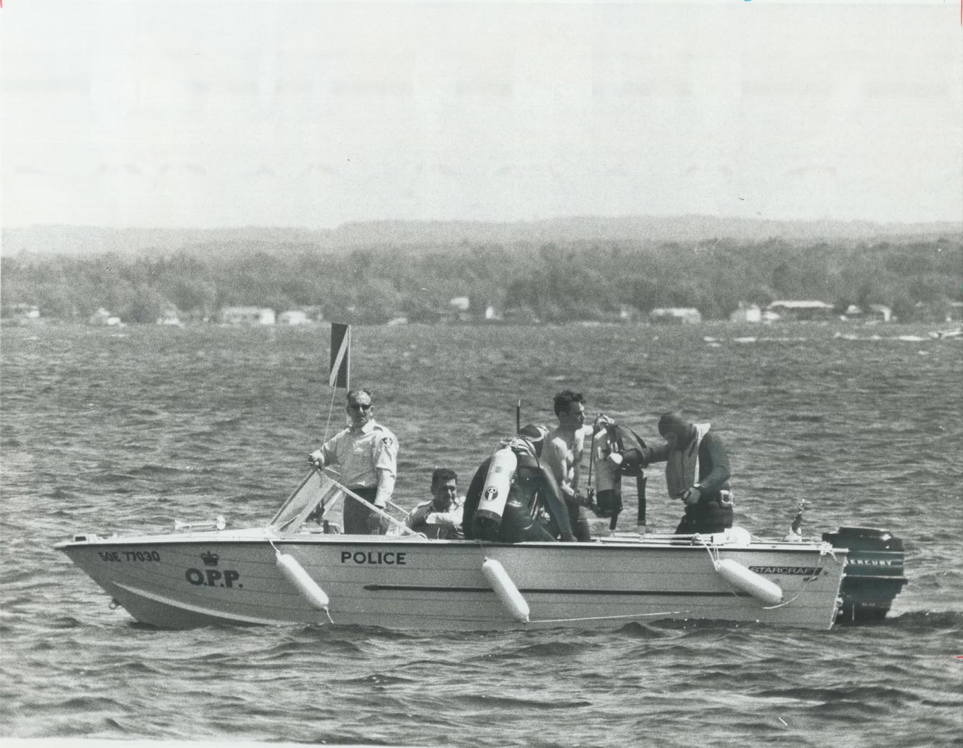 Scuba Divers in a police patrol boat prepare to dive into waters near Georgian Bay s Snake Island as they continue to search for drowning victims. Ten(...)