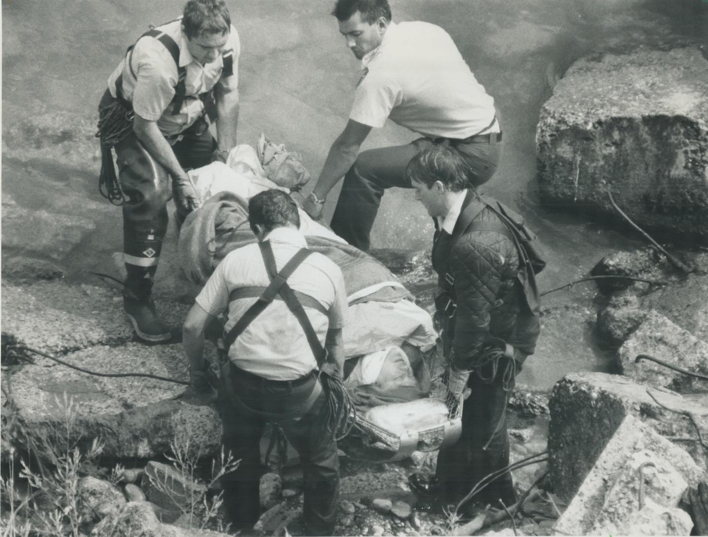 Rescuers prepare to remove a woman who fell about 21 metres (70 feet) down the Scarborough Bluffs yesterday