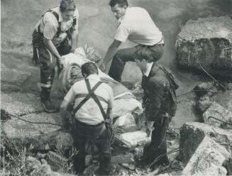 Rescuers prepare to remove a woman who fell about 21 metres (70 feet) down the Scarborough Bluffs yesterday