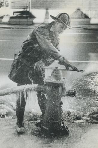 Coldest spot in town. A house is on fire only feet away, but fireman Wallace Gardiner finds it hard to believe as water sprays him in near-zero temper(...)