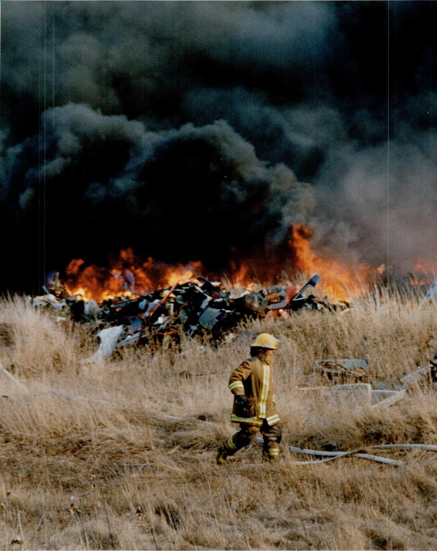 Newcastle fire fighters took about 14 hours to subdue this fire in an auto-parts yard on the Base Line Road, but it could continue to smolder for two weeks