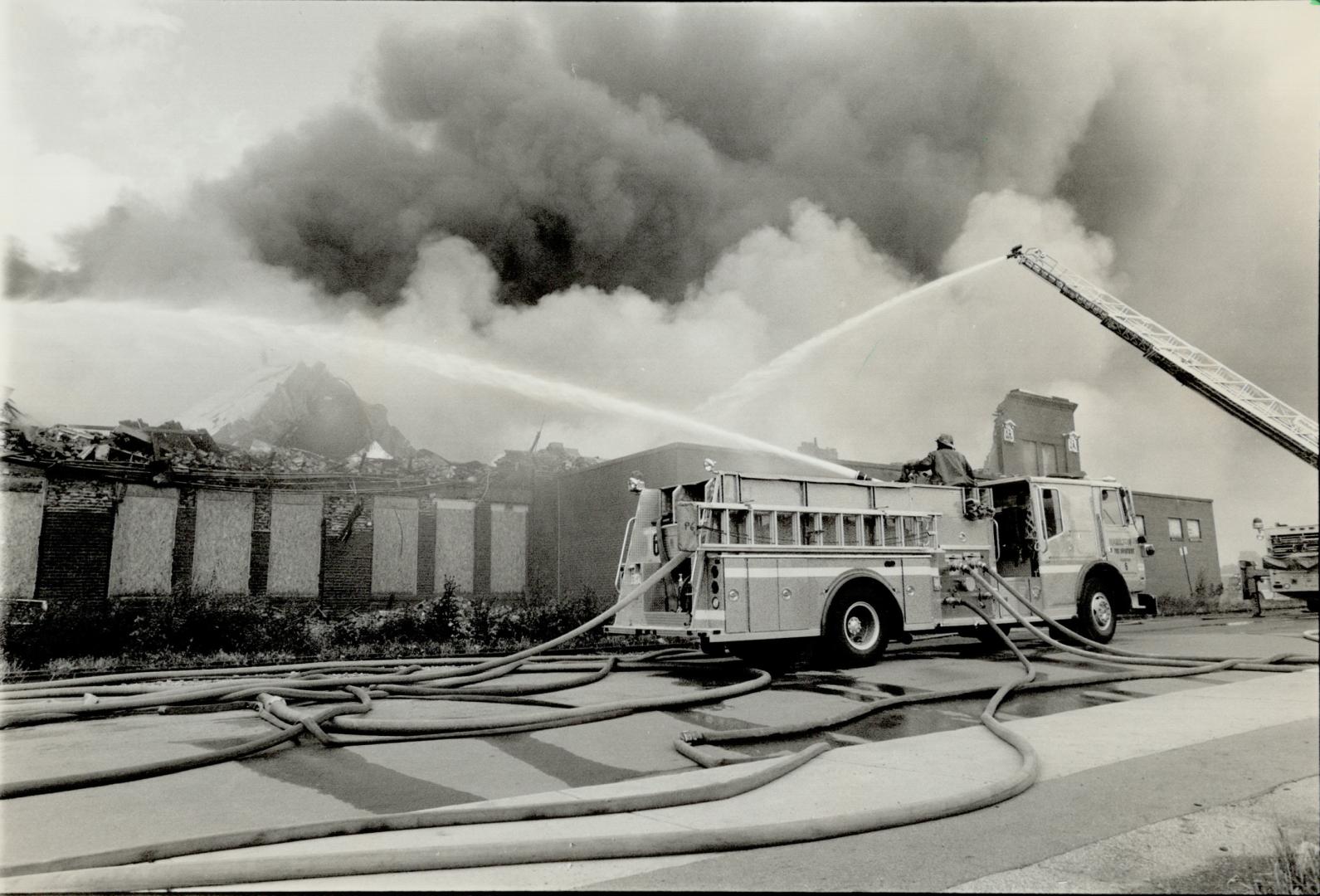 $750,000 Blaze: Smoke billows into the air as Hamilton firefighters train their hoses on a fire in an empty warehouse yesterday