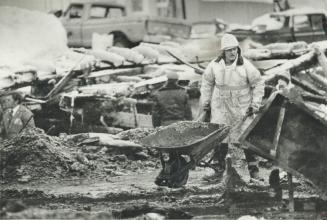 A fire captain wheels out ashes in a search for fire victims