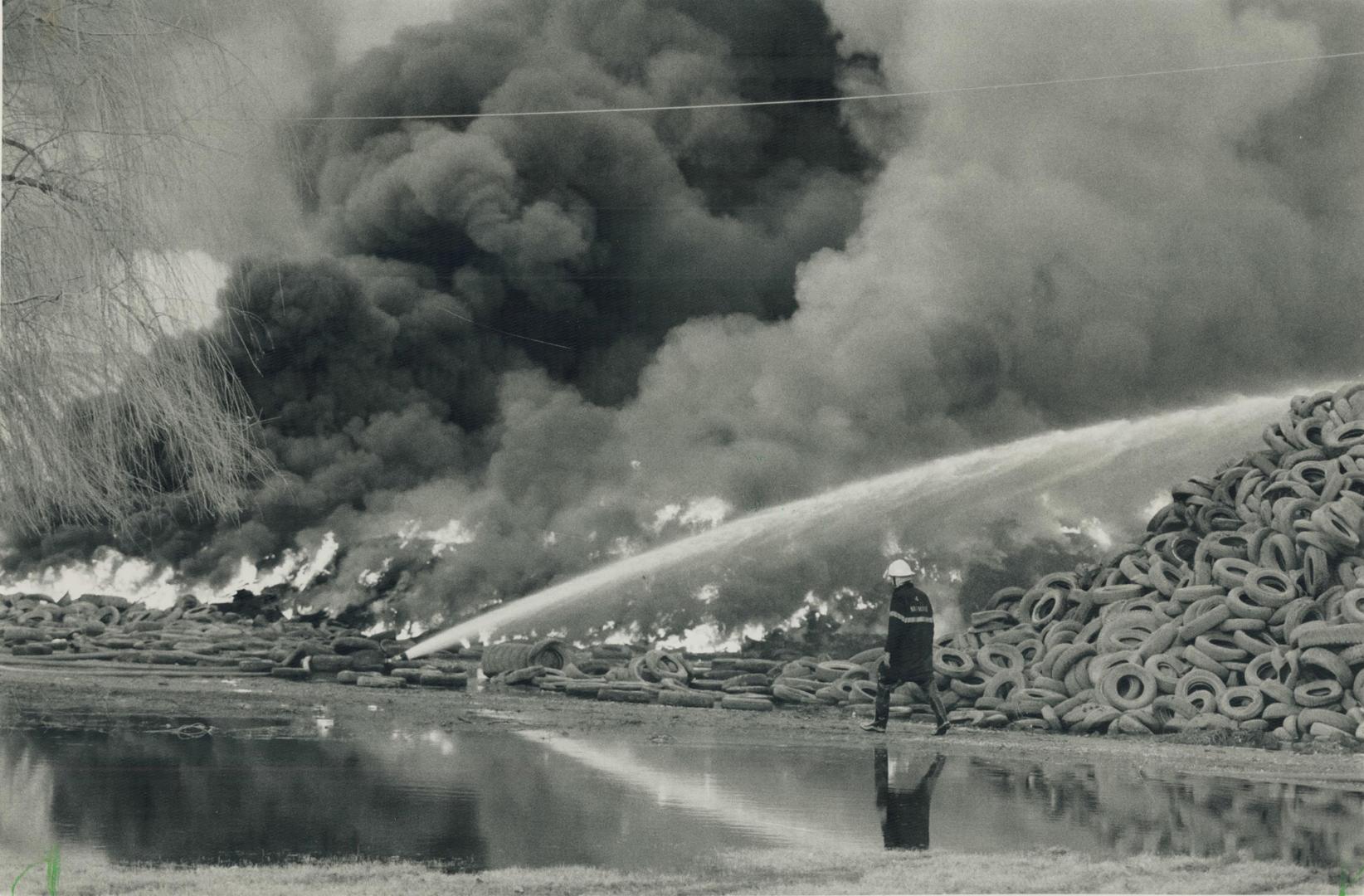 War zone: Water spews over mountain of tires as weary firefighter patrols grim scene in Hagersville