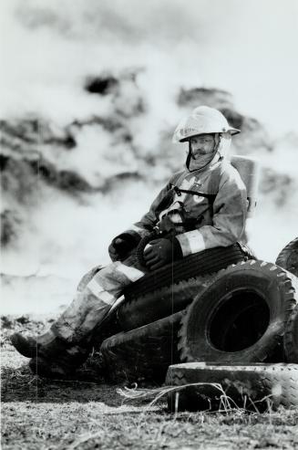 Dirty job: Firefighter takes a breather from battling acres of molten rubber