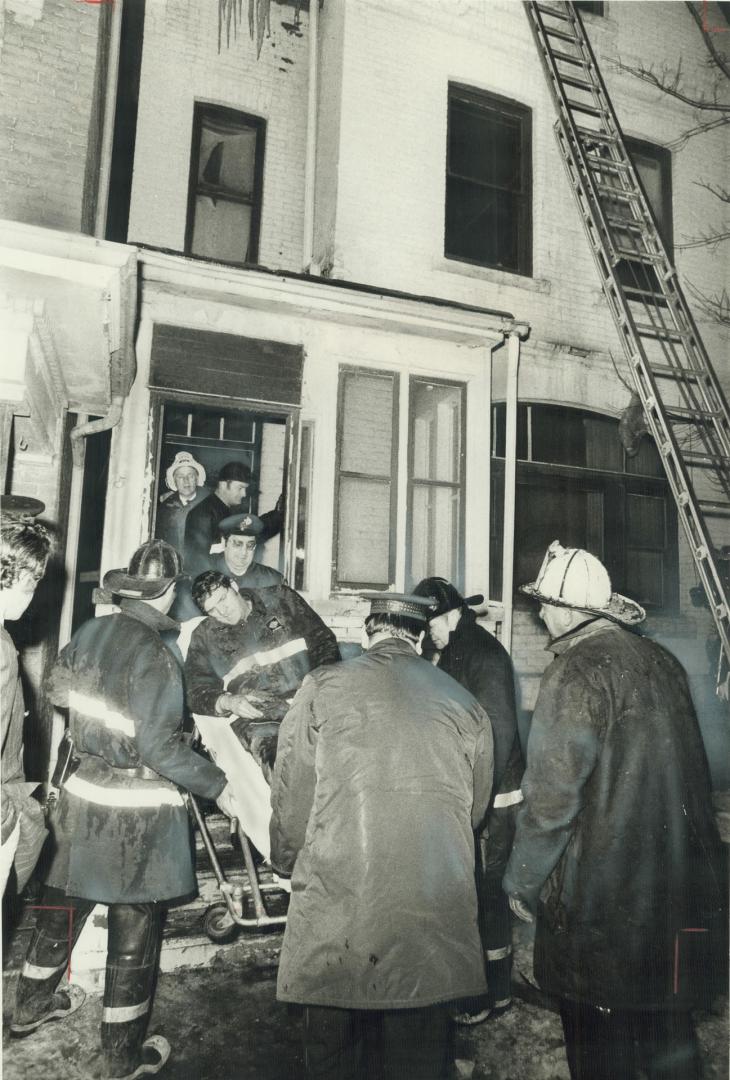 Injured fireman Ronald Seymour is carried out of a Gloucester St