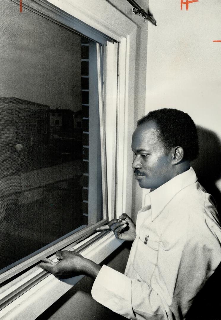 Screens are difficult to remove in the North York townhouse project where six persons died in a fire yesterday, as Herbert Green, a neighbor, shows. M(...)