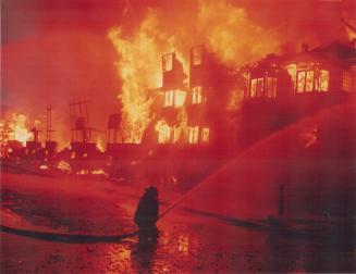 A firefighter battles a blaze at Adelaide St