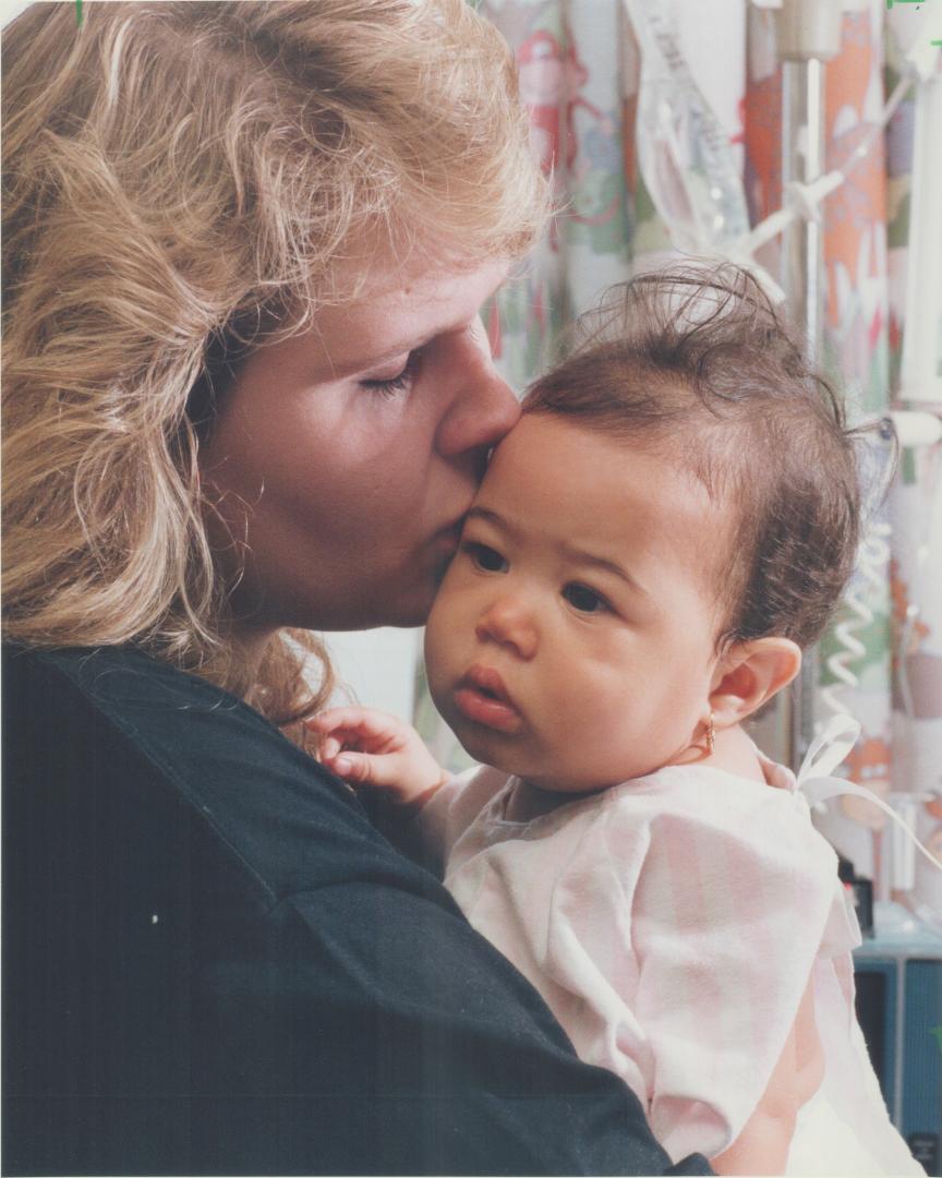 Painful lesson: Heidi Oehschlager hugs daughter Erika, 7 1/2 months, yesterday after the baby nearly drowned when left alone in a bathtub baby seat