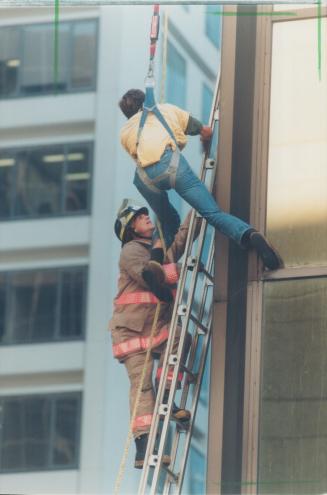 Gregory Hajdrych is rescued after hanging from the Guardian tower on University Ave