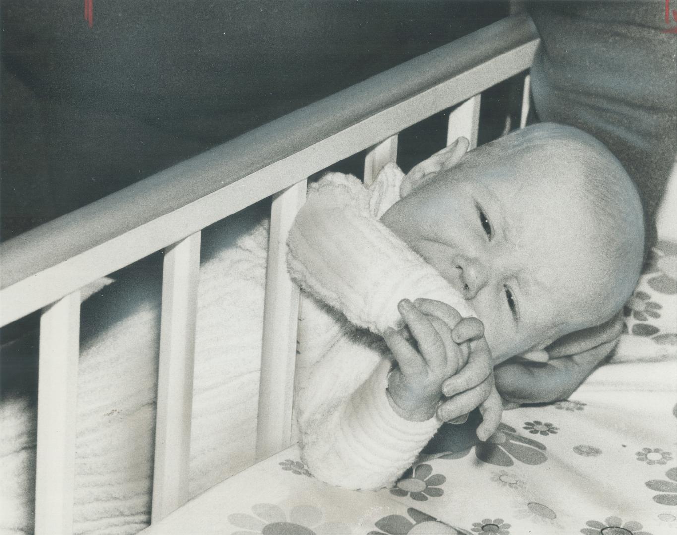 Kevin Wallace, who's 3 1/2 months old, shows how he slid through the bars of his crib last week