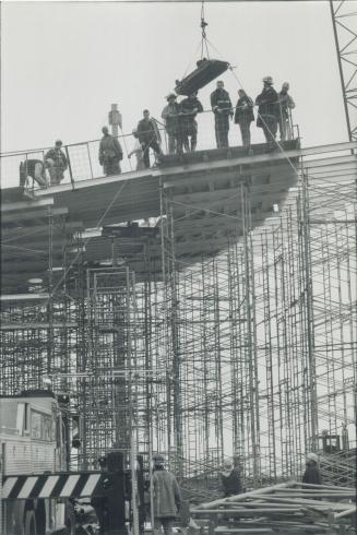 High wire heroics. Firefighters use a construction crane to lower an injured worker to safety yesterday from a stage being built at Harbourfront. The (...)