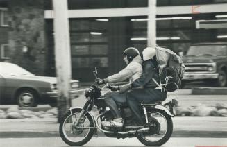 Heavily-laden motorcyclist heads back into Mississauga after evacuation order was partly lifted