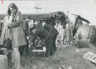 Stretcher party prepares to move an injured passenger from one of the damaged cars