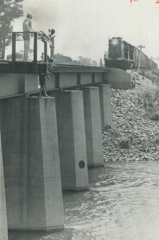 Flirting with death, youth waves at speeding freight train bearing down on him on a trestle