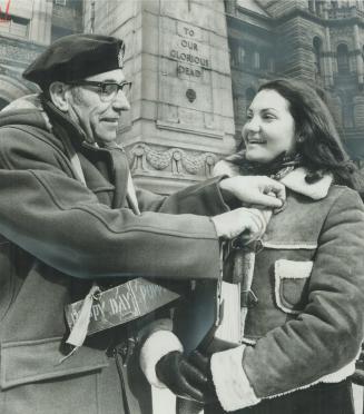 Legion member Paul Salij pins a poppy on Anne Shlarp outside old city hall