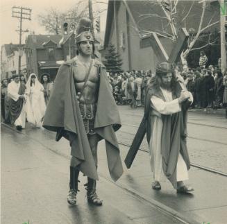 Sombre procession: Thousands of people brave the drizzle yesterday to watch a re-enactment of the crucifixion in the annual Good Friday parade through Little Italy