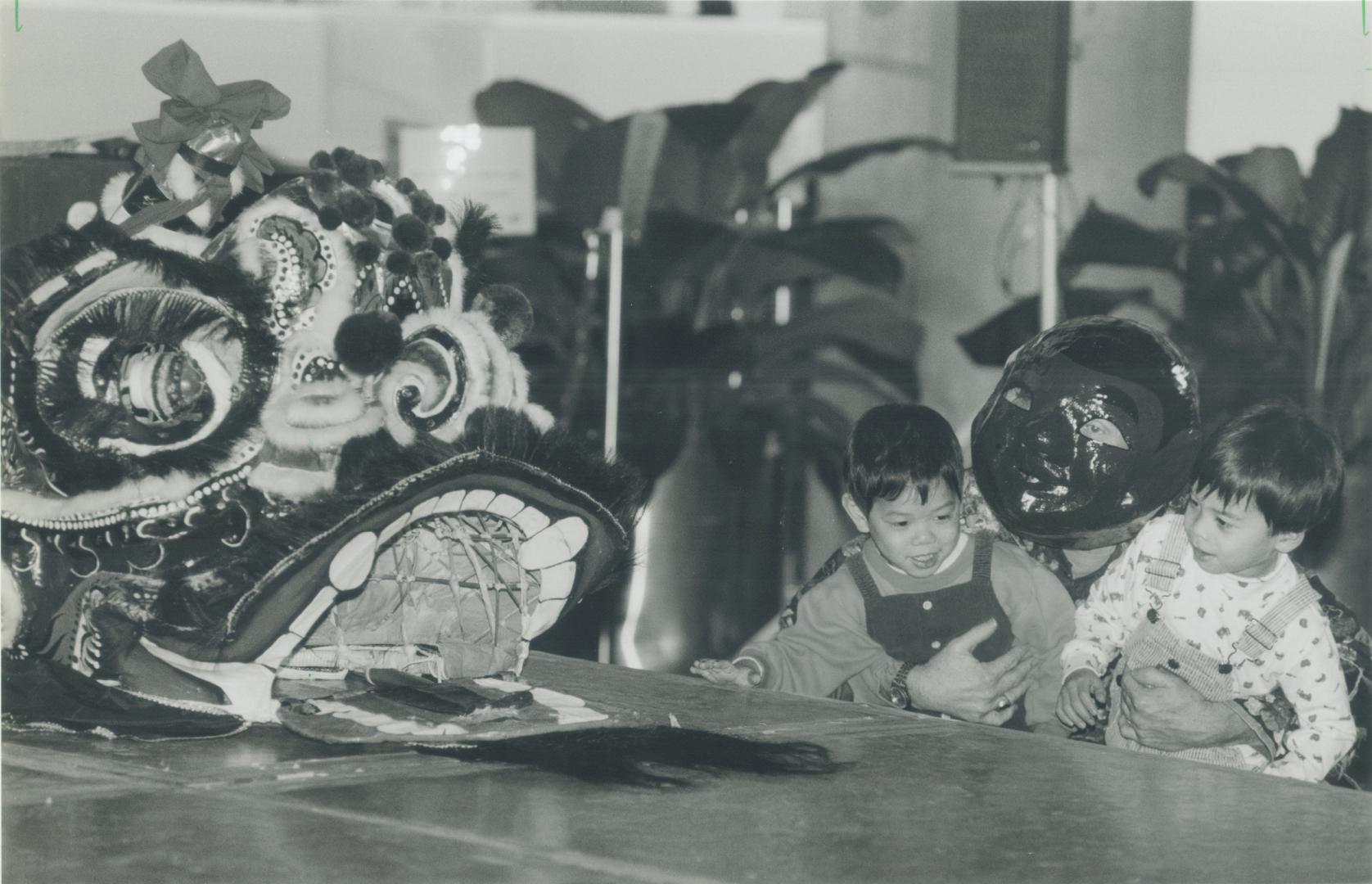 Hailing new year: Andrew Wong, 4, left, and Andrew MacKenzie, 5, are held up to the dragon at a Chinese New Year ceremony sponsored by the Chinese Business Association at city hall last night