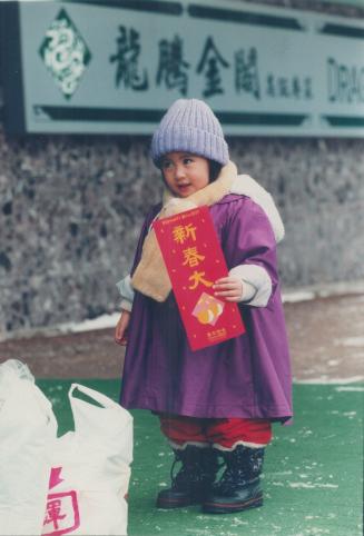 Ling, 3, who was born on Chinese New Year's Eve, holds lucky greeting