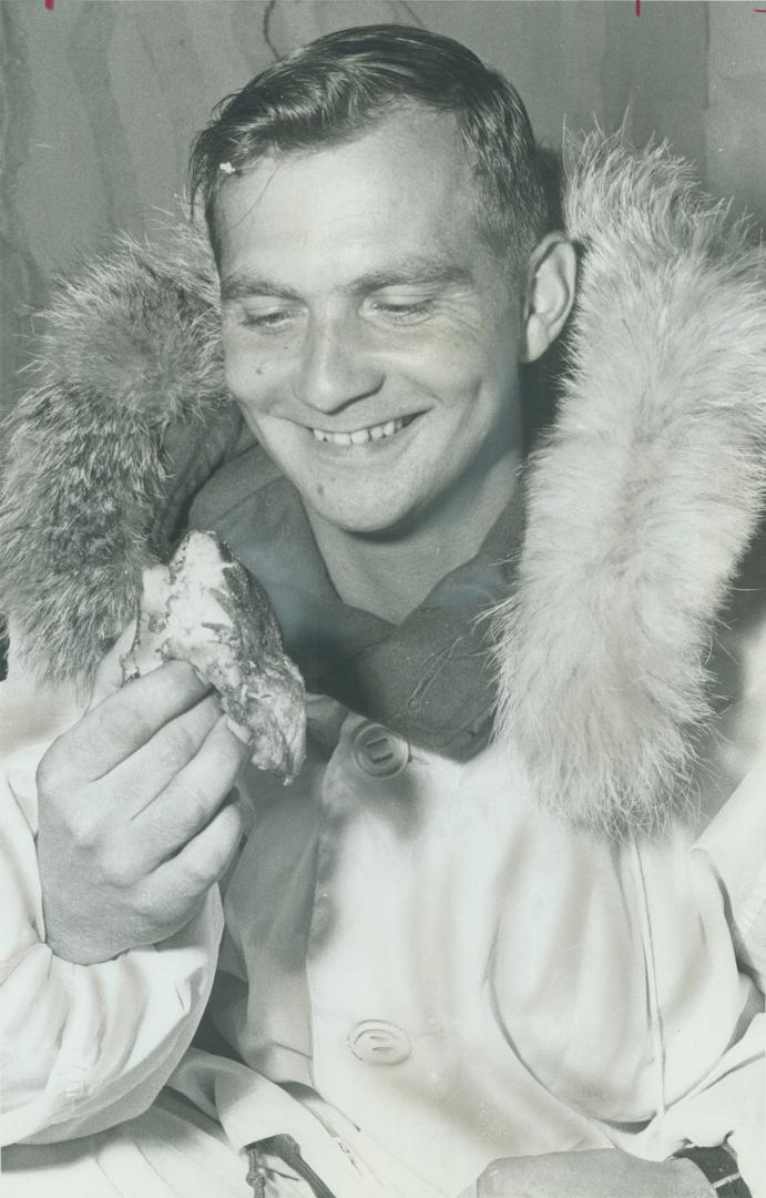 CPL. Frantz enjoys taste of freshly cooked Arctic Char. When men have time on Arctic exercises, they supplement rations with fish