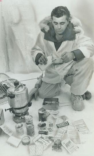 CPL. Gordon D'Andrea displays one man's daily food rations. Men serving in the Arctic devise ways to make regulation foods more interesting