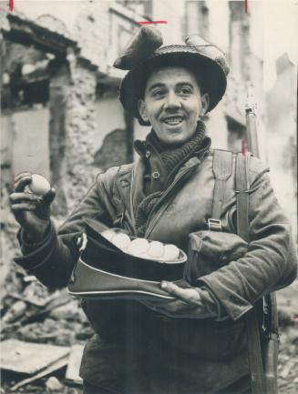 Easter's coming, too, remarks this tommy with the Canadians as he displays in a German officer's hat his haul of fresh eggs