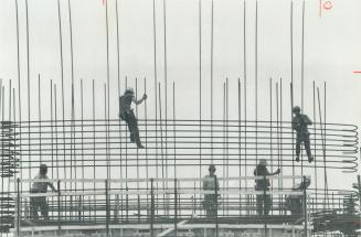 Weaving a network of power. Workmen appear to be weaving a network of steel reinforcing rods as Ontario Hydro expands its nuclear power-generating pla(...)