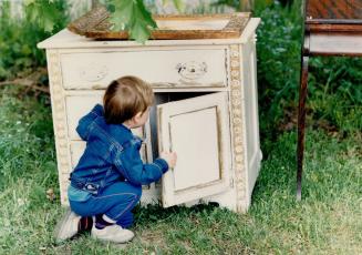 Michael Sturrock, 3, checks a cabinet