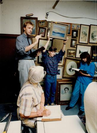 Left, Stephen Sweeting, assisted by wayne Booth, auctions a painting at D