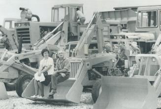 Whether the visitors were watching the action (like the people at left) or huddling in a conference, the $1 million auction of used construction equip(...)