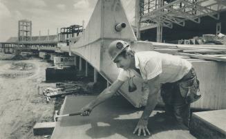 Above, carpenter Manuel Agostinho builds a form outside what will be the departures level