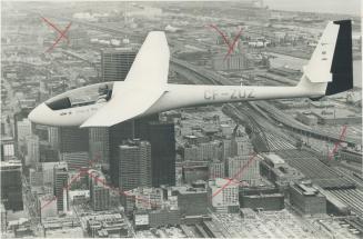 Gracing the sky above Toronto's waterfront area, Oscar Boesch stays aloft in his glider with the help of storm clouds