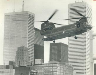 Swoosh. One of two Chinook helicopters cuts quite a swath over Metro's skies yesterday on its way to Moss Park Armouries. The choppers picked up 100 m(...)