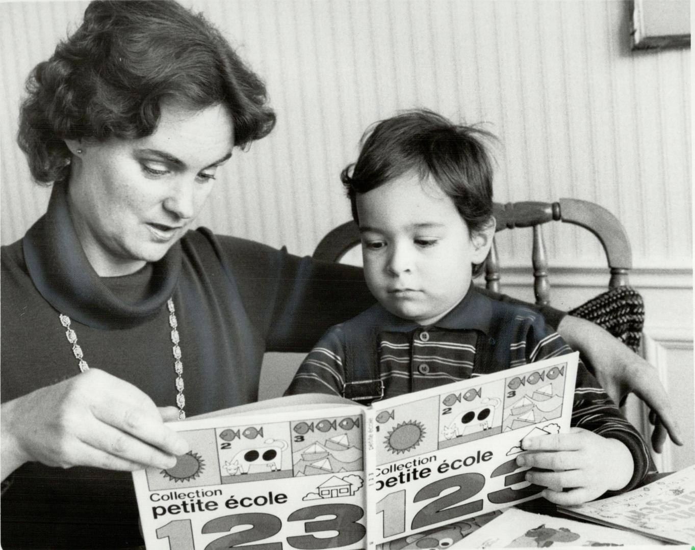 Two approaches to French: Stephanie Charron, above, teaches son Christian, whom she hopes to enrol in French immersion, with a French primer