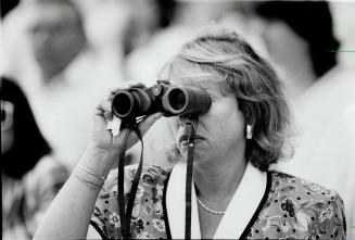 Looking for luck: A pair of serious spectators focus binoculars on the thoroughbreds in the 131st Queen's Plate at Woodbine yesterday