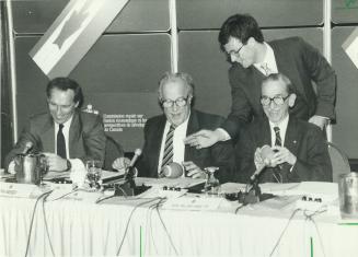 Political football: Student spokesman Tony Palmer backs up his argument by giving little footballs to royal commission members Laurent Picard, left, and William Hamilton